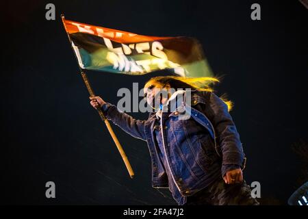 Apr 20, 2021 - Columbus, Ohio, USA - Shayna Muetzel, 23, aus Hilltop, steht auf ihrem Auto und schwenkt am 20. April 2021 in Columbus, Ohio, eine BLM-Flagge vor dem Ohio Statehouse. Eine Koalition von Black Lives Matter-Aktivisten organisierte eine schnelle Kundgebung zur Reaktion auf die Tötung des 16-jährigen Ma'Khia Bryant durch einen Polizeibeamten in Columbus. Der Tod des Mädchens forderte sofort einen Tribut an die Überschwänglichkeit, die Derek Chauvin bei der Tötung von George Floyd zuteil wurde. Die Polizei reagierte auf einen Bericht über einen Messervorfall im Südosten von Columbus. (Bild: © Eli Hiller/ZUMA Wire/ZUMAPRESS.com) Stockfoto