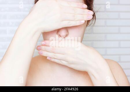 Junge kaukasische Frau mit ihren Händen, die Augen und Mund bedecken. Psychologische Probleme, psychische Störungen, betonte emotionale Zustand Konzept. Stockfoto
