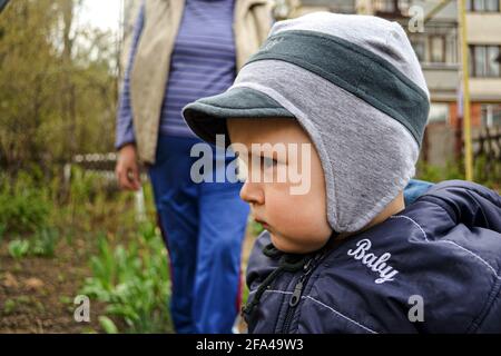 Kleiner Junge schaut Seite, während er im Garten steht Stockfoto