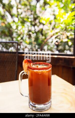 Michelada Bier mit Tomatensaft. Clamato mit Bier auf Holztisch. Stockfoto