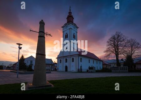 Kirche und Schlagpfosten auf dem Hauptplatz von Sucany, Slowakei. Stockfoto