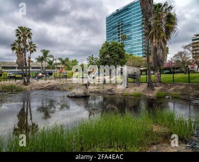 Los Angeles, CA, USA: 22. April 2021: Die Lake Pit an den La Brea Tar Pits zeigt eine Nachbildung eines Mammuts, das in Teer gefangen ist, Los Angeles, CA. Stockfoto
