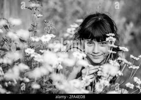 Porträt von Teenager-Mädchen zwischen Wildblumen. Schwarzweiß-Foto. Stockfoto