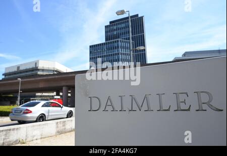 Stuttgart, Deutschland. April 2021. Vor dem Eingang zum Daimler-Hauptsitz und Hauptwerk in Stuttgart ist ein Daimler-Firmenlogo zu sehen. Links fährt ein Mercedes. Am 23. April werden die Quartalszahlen des Automobilkonzerns Daimler bekannt gegeben. Quelle: Bernd Weißbrod/dpa/Alamy Live News Stockfoto