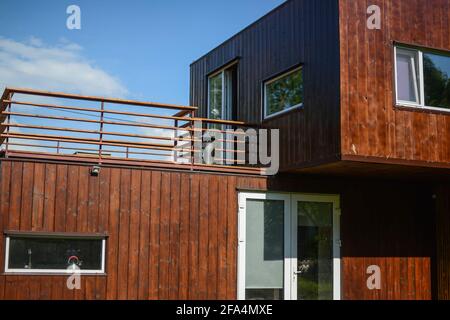 MINSK. WEISSRUSSLAND - Mai 2016: Blick auf eine hölzerne, braune Sommerterrasse. Wohnhaus im Hintergrund, blauer Himmel. Hochwertige Fotos Stockfoto