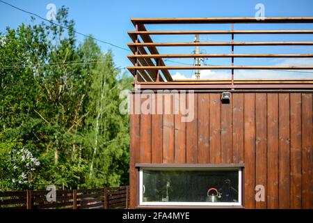 MINSK. WEISSRUSSLAND - Mai 2016: Blick auf eine hölzerne, braune Sommerterrasse. Wohnhaus im Hintergrund, blauer Himmel. Hochwertige Fotos Stockfoto