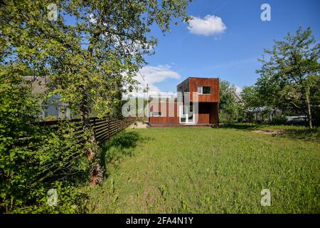 MINSK. WEISSRUSSLAND - MAI 2016: Blick auf das braune modulare Haus vor dem Hintergrund von Grün und blauem Himmel in den Wolken. Hochwertige Fotos Stockfoto