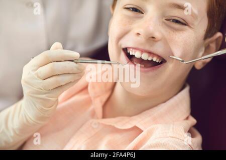 Nahaufnahme Porträt eines niedlichen kleinen Jungen während der zahnärztlichen Untersuchung und Reinigung Zahnbelag. Stockfoto