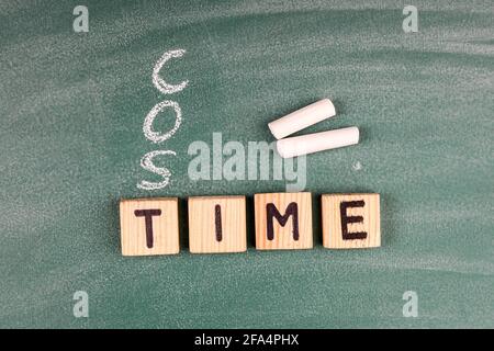 Zeit ein Kostenkonzept. Hölzerne Buchstaben auf einem grünen Kreidetafel. Stockfoto