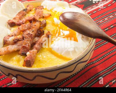 Polenta mit Käse und Eiern und Speck, rumänisches Gericht Stockfoto