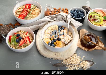 Haferflockenschalen mit köstlichen Früchten und frischen Beeren auf hellem Hintergrund. Gesundes Frühstückskonzept. Stockfoto