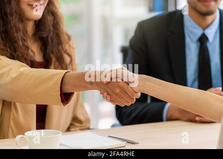 Nahaufnahme Händedruck beim Interview zwischen junger asiatischer Frau und zwei manager mit positiver Bewegung im Besprechungsraum, Geschäftsanstellung neuer Mitarbeiter Konzept Stockfoto