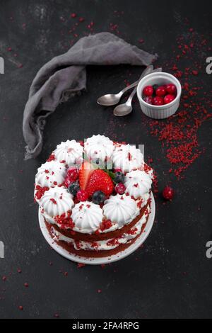 Köstliche hausgemachte rote Samtkuchen mit Baiser und Mascarpone-Creme auf schwarzem Hintergrund. Stockfoto