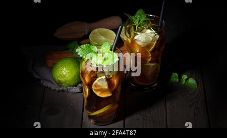 Frisch zubereitetes Longdrink Cuba Libre Cocktail auf dunklem Hintergrund. Panorama, Kopierbereich Stockfoto