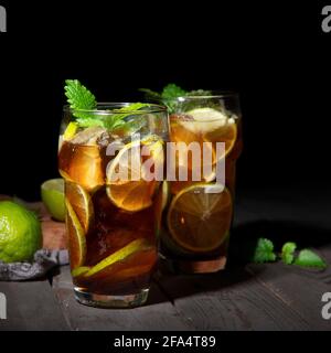 Frisch zubereitetes Longdrink Cuba Libre Cocktail auf dunklem Hintergrund. Vorderansicht, Kopierbereich Stockfoto