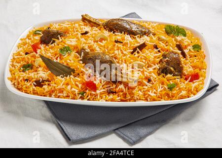 Indische oder pakistanische Küche. Hammelfleisch Biryani Reisbiriany mit Minzkraut und Naan-Brot auf grünem Hintergrund. Stockfoto