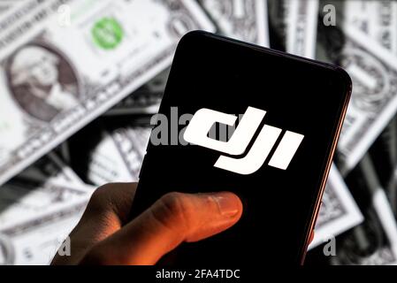 In diesem Foto Illustration der chinesischen Technologie Drohne Unternehmen, DJI-Logo auf einem Android-Handy-Bildschirm mit der Währung des US-Dollar-Symbol gesehen, Dollar-Symbol im Hintergrund. Stockfoto