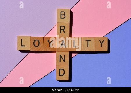 Marke, Loyalität, Wörter in hölzernen Alphabeten in Kreuzworträtsel-Form isoliert auf buntem Hintergrund Stockfoto