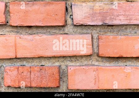 Alte Backsteinmauer mit verwitterten Details aus der Nähe Stockfoto