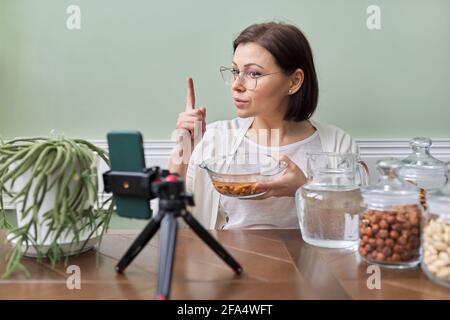 Ernährungswissenschaftler spricht über die Vorteile des Einweichens von Nüssen in Wasser, Aufnahme Video Blog vlog Stockfoto