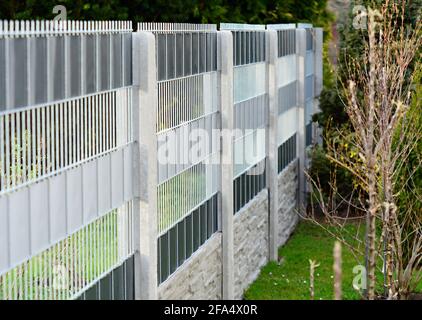 Gartenzaun mit dekorativen verzinkten Drahtzaun Platten in die Betonsäulen eingefügt gemacht. Stockfoto