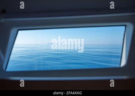 Blick vom Yachtfenster auf die Blue Tones Wasserwellen-Oberfläche Stockfoto