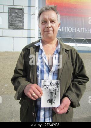 01. April 2021, Ukraine, Kiew: Ilya Suslov hält ein Foto von sich in den Händen. Als Student im Jahr 1986 reiste Ilya Suslov von Navoiy in Usbekistan, 3000 Kilometer entfernt, zum beschädigten Kernkraftwerk Tschernobyl. Von Mitte August bis Mitte Oktober arbeitete der damals 25-Jährige als Vorarbeiter am Bau des ersten Beton-Sarkophags. Nach dem Zusammenbruch der Sowjetunion zog der jetzt 60-Jährige nach Kiew in die jetzt unabhängige Ukraine und ist nun Rentner mit Behinderungen. (To dpa '35 Jahre Tschernobyl: Nuklearer Unfall belastet Zeugen und Politik') Foto: Andreas Stein/dpa Stockfoto