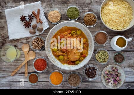 Traditionelles Tagine-Gericht mit Grieß und Gewürzen auf dem Teller Auf dem Holztisch Stockfoto