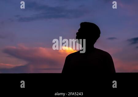 Silhouette des asiatischen Mannes allein bleiben mit Dämmerung Himmel Hintergrund. Depression und psychische Gesundheit Konzept. Stockfoto