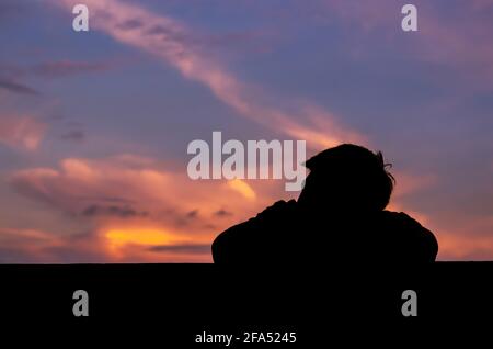 Silhouette des asiatischen Mannes allein bleiben mit Dämmerung Himmel Hintergrund. Depression und psychische Gesundheit Konzept. Stockfoto