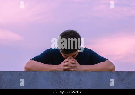 Asian miserable depressiven Mann bleiben allein mit Himmel Hintergrund. Depression und psychische Gesundheit Konzept. Stockfoto