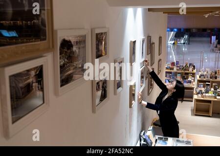 (210423) -- HARBIN, 23. April 2021 (Xinhua) -- Yu Bing rejusts Wall decorations at M.I. Buchhandlung in Harbin, nordöstlich der Provinz Heilongjiang, 22. April 2021. Für Yu Bing, den Manager der Buchhandlung aus Harbin, ging es immer darum, eine ermutigende Leseumgebung zu schaffen. Yu, geboren und aufgewachsen in Harbin, ist heute ein Veteran mit 10 Jahren Erfahrung im Buchhandel. Yu sagt, der größte Wert ihres Berufs sei die Schaffung einer effektiven Plattform für den Austausch guter Bücher -- 'wie kann man ein verlockend Layout erstellen, das potenzielle Kunden anzieht? Und wie man p Stockfoto