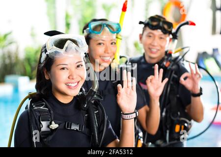 Asiaten in der Diver Kurs im Urlaub im Neoprenanzug mit einer Sauerstoffflasche Stockfoto