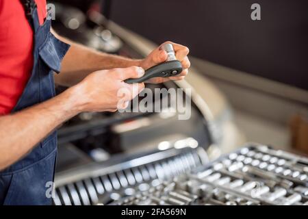 Männliche Hände mit Detail in Autowerkstatt Stockfoto