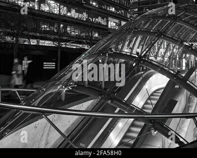 Ein bewegungsunscharfer Spaziergang führte durch den eleganten, ultramodernen Eingang zur U-Bahn-Station Canary Wharf mit geometrischen Bürobeleuchtung. Stockfoto