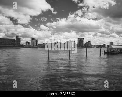 Eine langsame, infrarotgefilterte, monochrome Ansicht über die Themse vom kanadischen Wasser bis zu neuen Wohngebäuden auf der anderen Seite des Flusses. Stockfoto