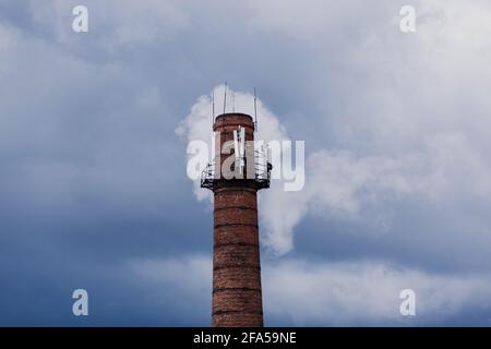 Luftverschmutzung durch Rauch aus Fabrikschornsteinen. Ziegelrohr auf Himmel Hintergrund Stockfoto