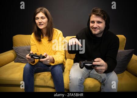 Abends Familienunterhaltung. Lächelnd lässig gekleidetes Paar spielt Videospiel Stockfoto