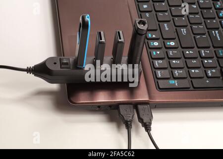 Vollständig verwendeter USB-Hub (jedes Gerät ist mit einem Gerät verbunden), der mit dem Laptop verbunden ist. Stockfoto