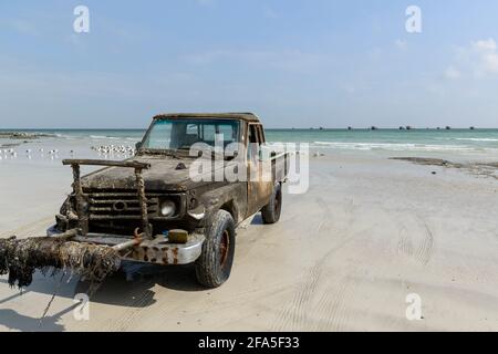 Angelmöglichkeiten am Strand in der Nähe des Dorfes Al-Khalufa, Oman. Der alte Toyota Landcruiser pflegte die Fischerboote ein. Stockfoto