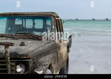 Angelmöglichkeiten am Strand in der Nähe des Dorfes Al-Khalufa, Oman. Der alte Toyota Landcruiser pflegte die Fischerboote ein. Stockfoto