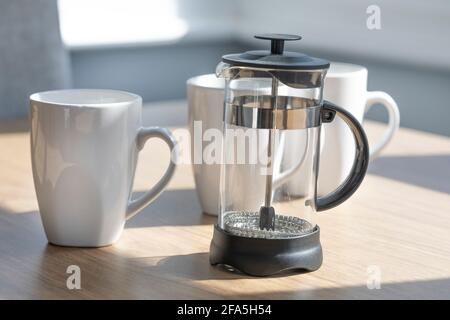 Eine Cafetiere und weiße Kaffeetassen Stockfoto