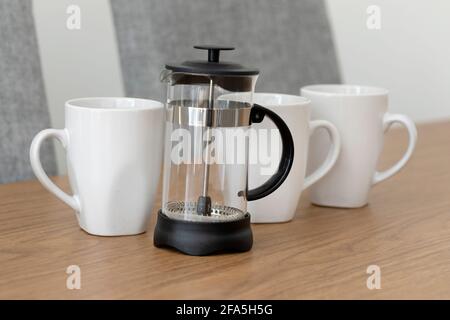 Eine Cafetiere und weiße Kaffeetassen Stockfoto