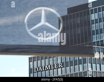 Stuttgart, Deutschland. April 2021. An einem Gebäude am Hauptsitz des Stuttgarter Automobilherstellers Daimler ist ein Daimler-Firmenlogo angebracht, im Vordergrund eine Flagge mit einem Mercedes-Stern. Die Quartalszahlen des Automobilkonzerns Daimler werden am 23. April bekannt gegeben. Quelle: Bernd Weißbrod/dpa/Alamy Live News Stockfoto