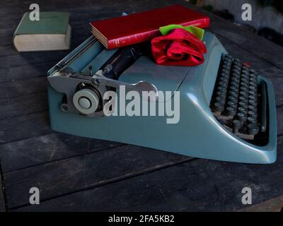 Eine Rose auf einem Stapel von Büchern und Eine Schreibmaschine Stockfoto
