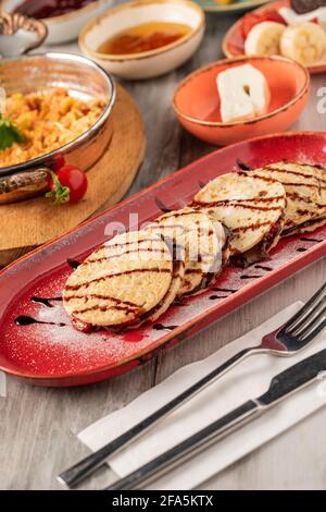 Pfannkuchen mit Erdbeere und Schokolade auf einem roten Teller. Stockfoto