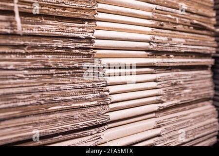 Große Kartonstapel liegen in einem Lagerhaus übereinander. Konzept der Lagerung von Sachen und umweltfreundlichem Material. Verlängerbar Stockfoto