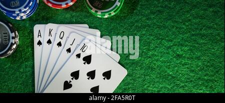 royal Flush im Pokerspiel. Karten mit Casino-Chips auf grünem Stofftisch. Banner-Kopierraum Stockfoto