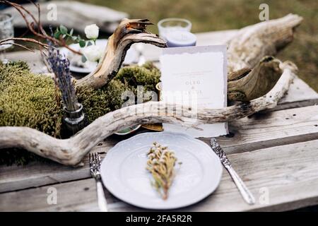 Die weiße Visitenkarte steht auf einem wunderschön servierten rustikalen Tisch Mit Blumen und Blumensträußen Stockfoto