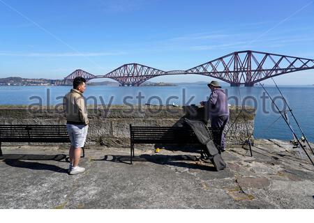 South Queensferry, Schottland, Großbritannien. April 2021. Klar warm und sonnig an der South Queensferry. Menschen, die das Beste aus dem guten Wetter machen und beginnen, die Natur an den üblichen Besucher-Hotspots zu besuchen und zu genießen. Angeln am Pier. Kredit: Craig Brown/Alamy Live Nachrichten Stockfoto